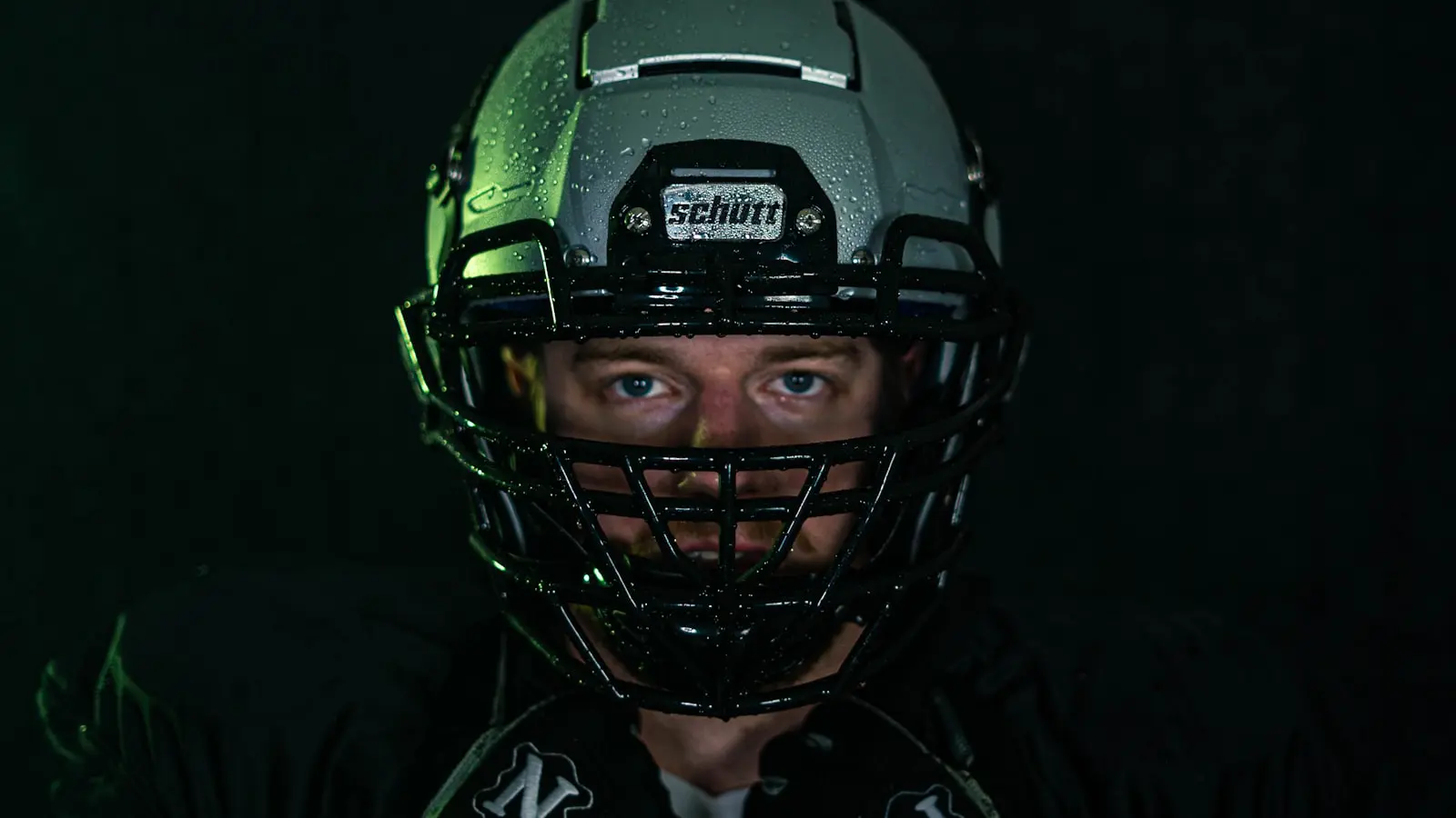 Why do NFL quarterbacks wear a microphone in their helmet?
